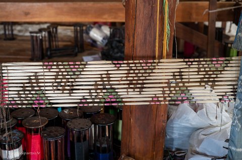 20191122__00289-137 Myat Pwint Chel, Tissage de soie de lotus, ensemble de fils avant teinture avec des élastiques qui marquent les endroits à teinter et ceux à ne pas teinter, en...